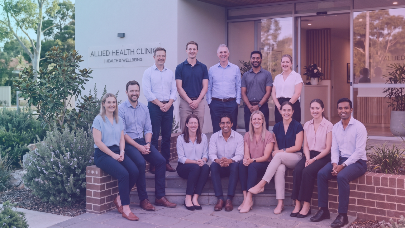 Group of therapists standing and sitting outside a clinic
