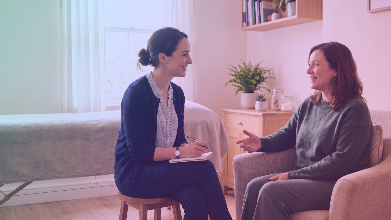 2 Women in a clinic, one therapist taking notes during a consultation